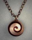 Spiral Sphere pendant of bronze with copper inlay spiral, measuring ¾” dia. and hangs on a bronze 18” to 23” adjustable length chain.
