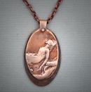 Bronze oval pendant with image of a reclining woman; L= 2  W= 1.