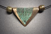 Bronze triangular shaped pendant of a leaf with a green patina, sitting between 2 bronze beads. Leaf measures ¾”w x 7/8”w and hangs on Memory Wire.