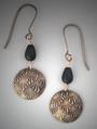 Hand-sculpted Bronze earrings.  A domed circle of bronze with V-lines pattern below an oval matt glass bead. L= 2 1/16� (including ear wire)  W= ¾�